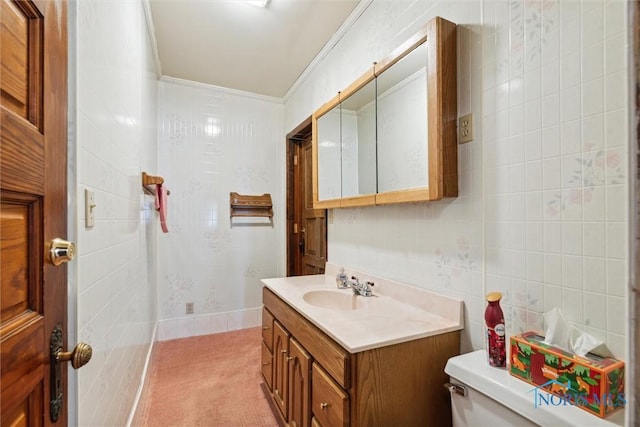 bathroom with vanity, toilet, tile walls, and ornamental molding