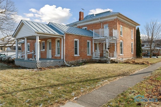 view of side of property with a yard and covered porch