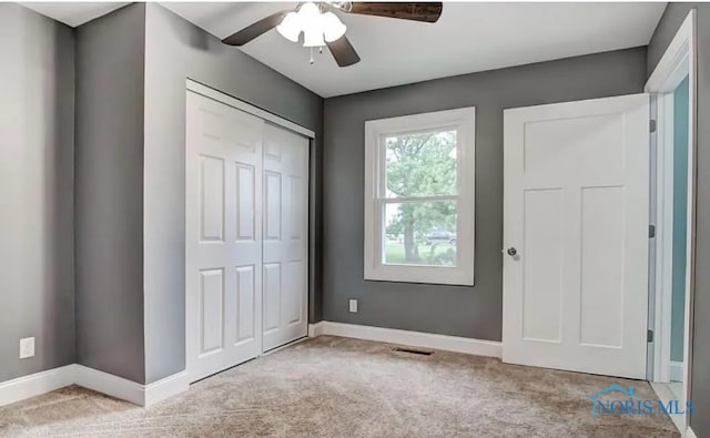 unfurnished bedroom featuring a closet, ceiling fan, and light colored carpet