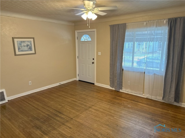 foyer entrance with ceiling fan, wood-type flooring, and a textured ceiling