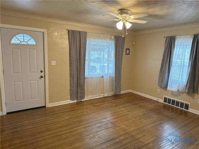 foyer with a wealth of natural light, ceiling fan, and dark hardwood / wood-style floors