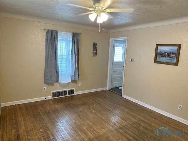 unfurnished room with hardwood / wood-style flooring, plenty of natural light, ceiling fan, and a textured ceiling