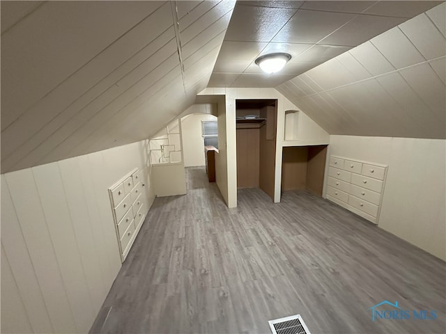 additional living space with light wood-type flooring and lofted ceiling