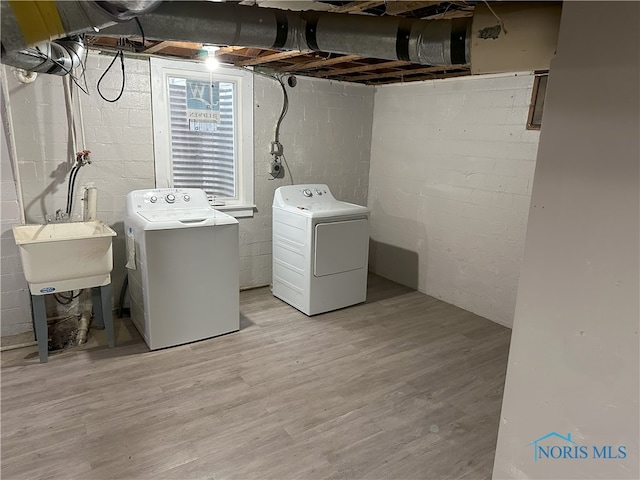 washroom featuring washer and clothes dryer, light hardwood / wood-style floors, and sink