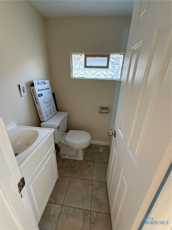 bathroom featuring tile patterned flooring, vanity, and toilet