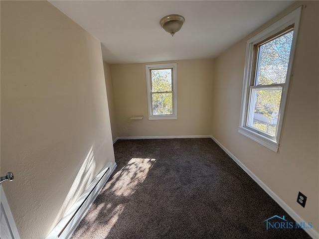 carpeted spare room featuring a baseboard heating unit