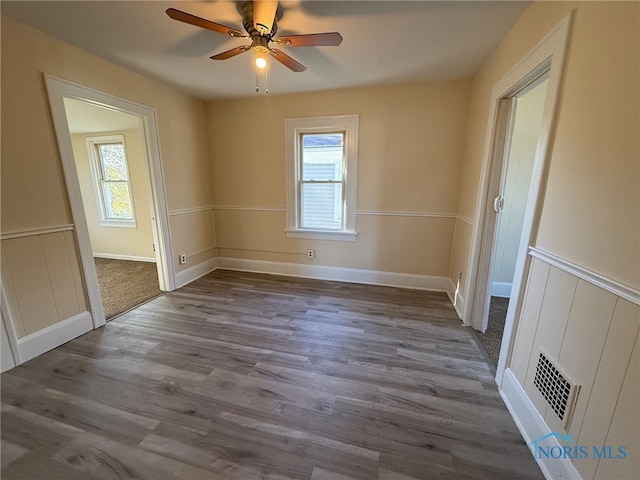 spare room featuring hardwood / wood-style floors, a wealth of natural light, and ceiling fan