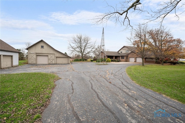 single story home featuring an outbuilding, a front lawn, and a garage