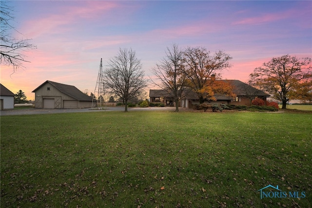 yard at dusk with an outbuilding and a garage