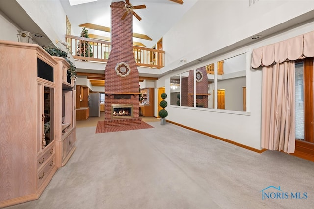 unfurnished living room with light carpet, high vaulted ceiling, a fireplace, and ceiling fan