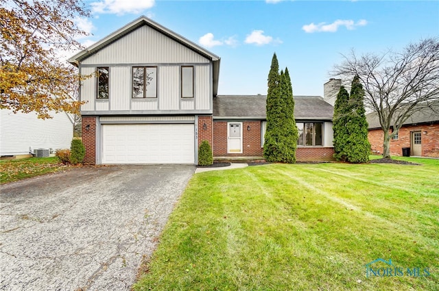 view of front of home featuring cooling unit, a front lawn, and a garage