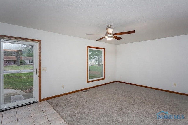 carpeted spare room featuring a textured ceiling and ceiling fan