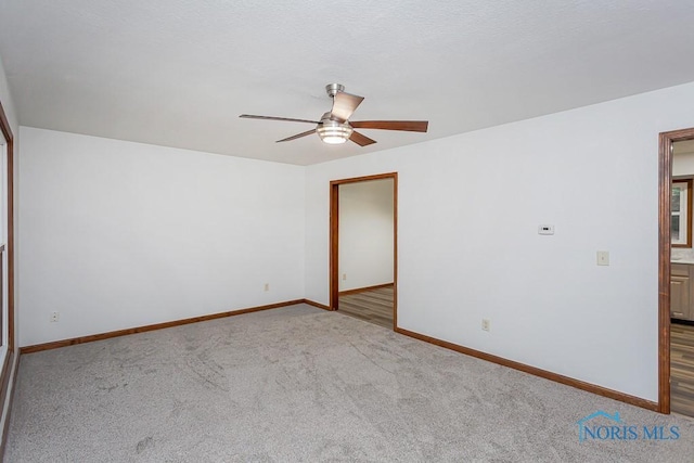 spare room featuring light colored carpet and ceiling fan