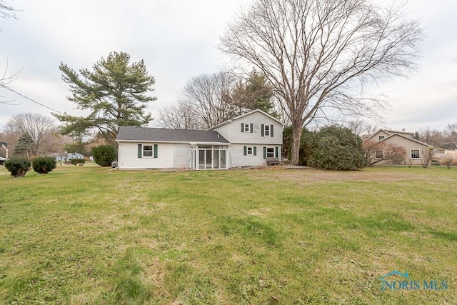 back of property with a sunroom and a yard