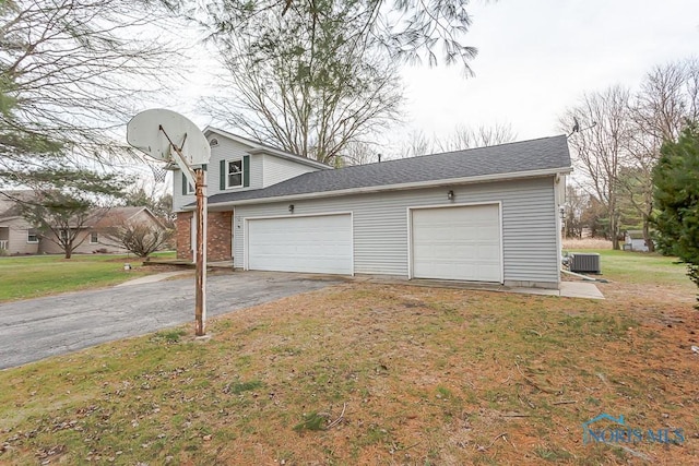 garage with a lawn and central air condition unit