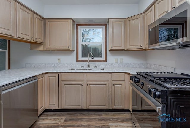 kitchen with light brown cabinets, sink, stainless steel appliances, and dark wood-type flooring