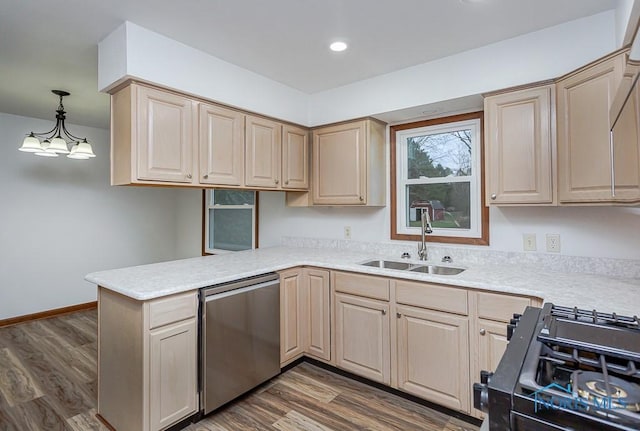 kitchen featuring kitchen peninsula, black range oven, sink, decorative light fixtures, and dishwasher