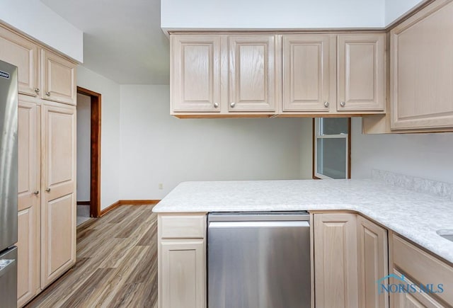 kitchen with kitchen peninsula, light brown cabinetry, and hardwood / wood-style flooring