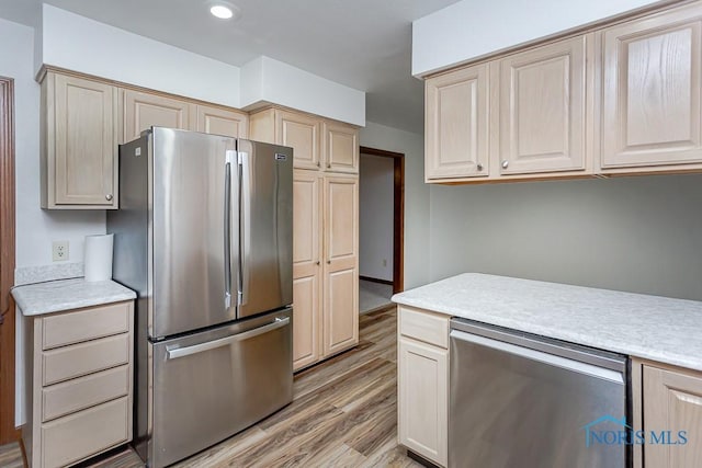 kitchen with appliances with stainless steel finishes and light hardwood / wood-style flooring