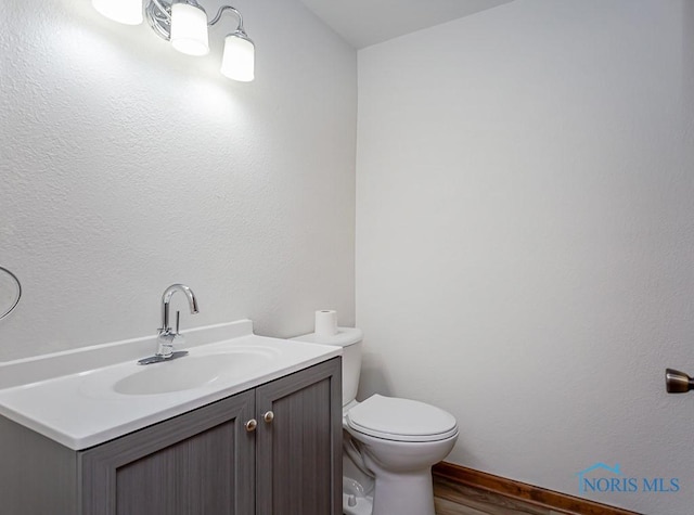 bathroom featuring hardwood / wood-style floors, vanity, and toilet