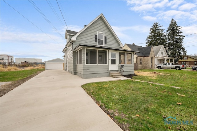 bungalow-style house with a sunroom, a garage, an outdoor structure, and a front lawn