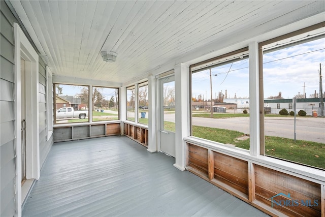 unfurnished sunroom with wooden ceiling and a healthy amount of sunlight