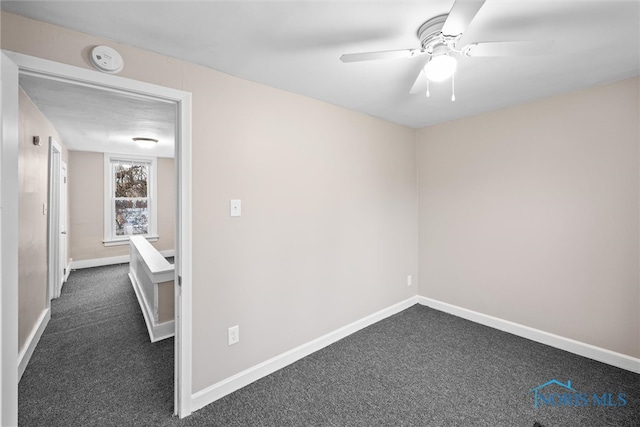 carpeted spare room featuring ceiling fan