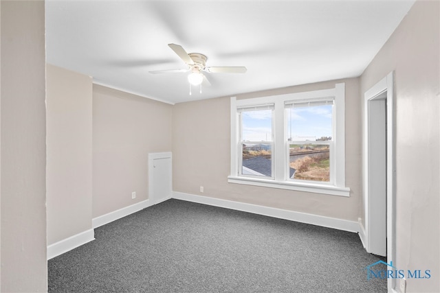 carpeted spare room featuring ceiling fan