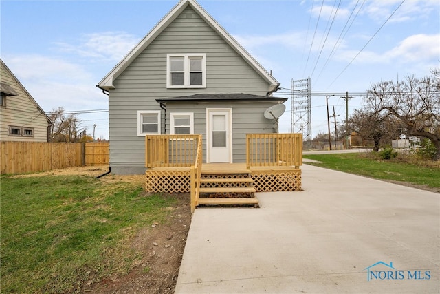 rear view of house featuring a yard and a wooden deck