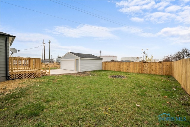 view of yard featuring a garage, an outbuilding, and a wooden deck