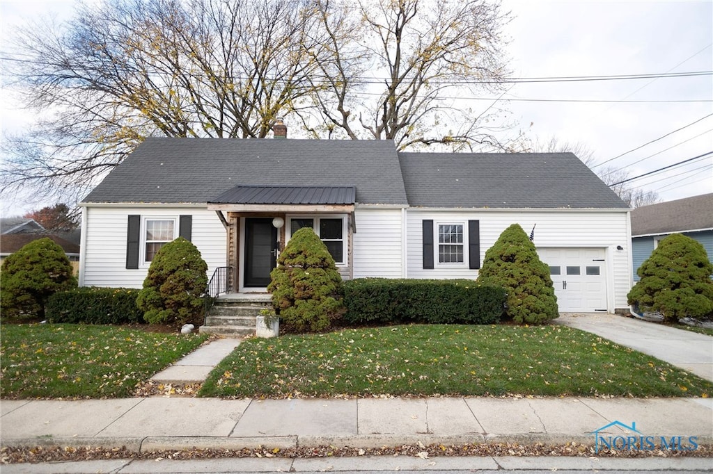 view of front of home with a garage and a front lawn