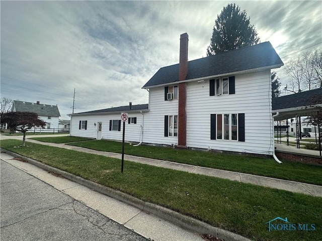 colonial house featuring a front lawn