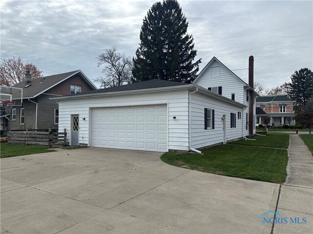 view of side of property featuring a yard and a garage