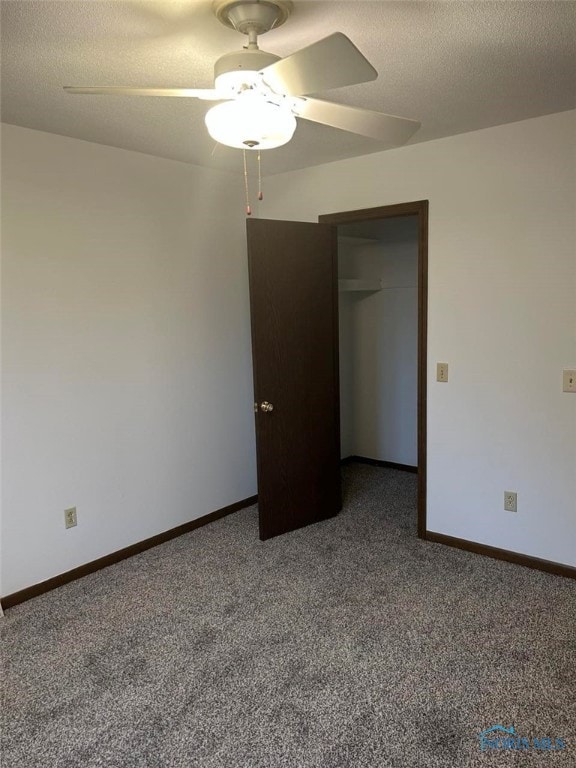 spare room featuring ceiling fan, carpet, and a textured ceiling