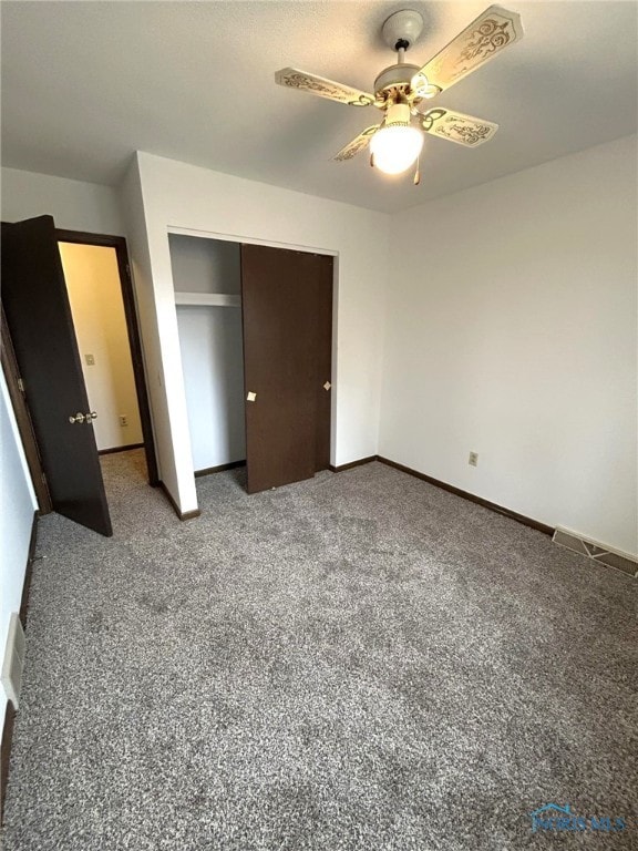 unfurnished bedroom with ceiling fan, carpet flooring, and a closet