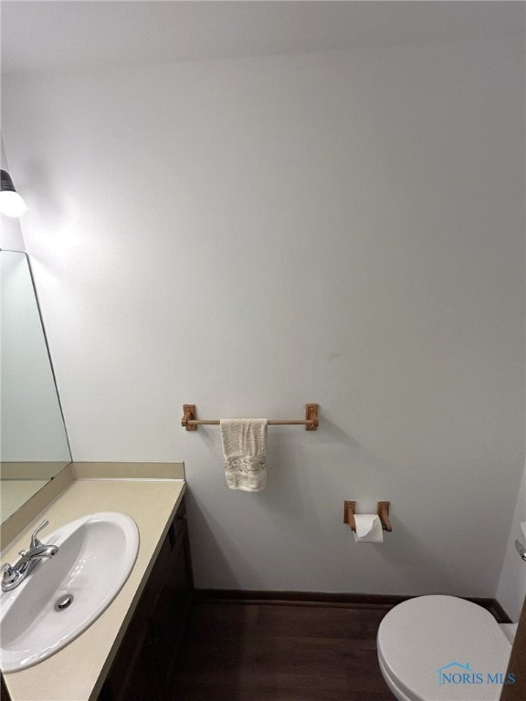 bathroom featuring vanity, hardwood / wood-style flooring, and toilet