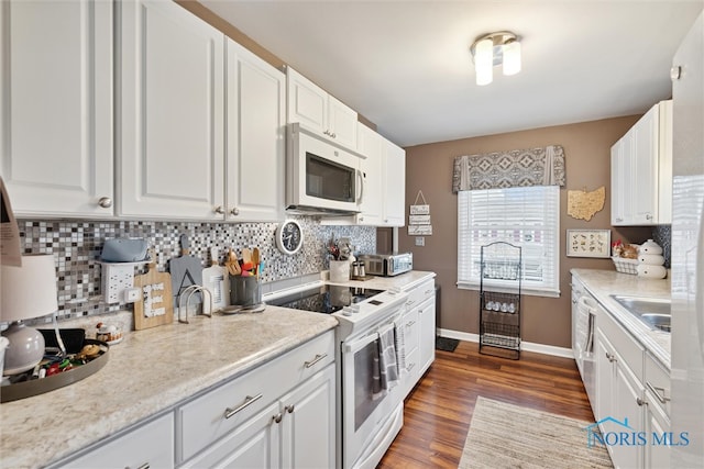 kitchen featuring white appliances, dark hardwood / wood-style floors, white cabinetry, and tasteful backsplash