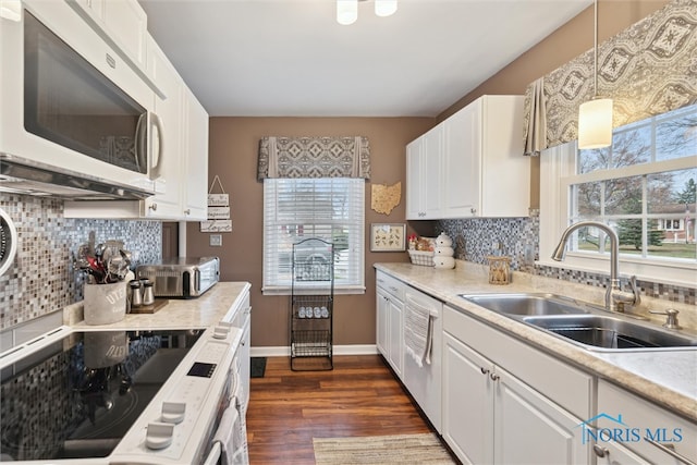 kitchen featuring sink, white cabinets, pendant lighting, and appliances with stainless steel finishes