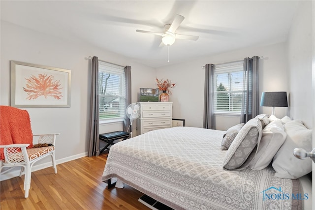 bedroom with light hardwood / wood-style floors, multiple windows, and ceiling fan