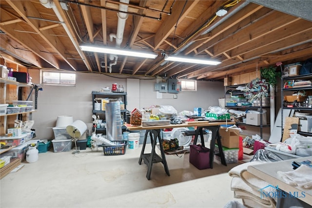 basement with a workshop area, a healthy amount of sunlight, and electric panel