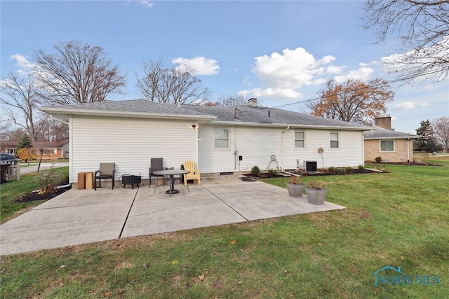 back of house featuring central AC unit, a patio area, and a lawn