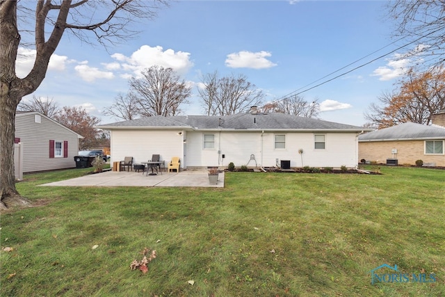 back of property with a lawn, central air condition unit, and a patio