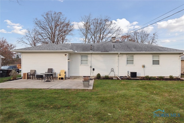 rear view of house with a lawn, central AC unit, and a patio area