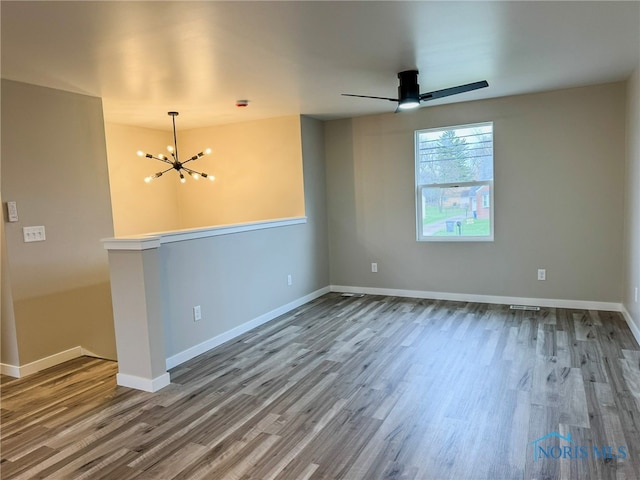 unfurnished room featuring hardwood / wood-style flooring and ceiling fan with notable chandelier