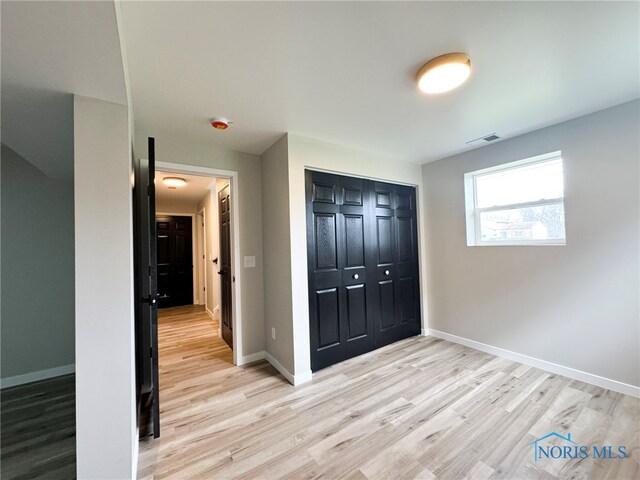 unfurnished bedroom featuring a closet and light hardwood / wood-style flooring