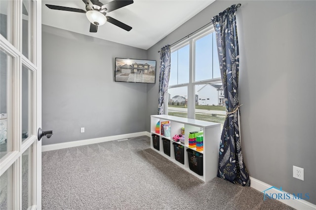 playroom with ceiling fan and carpet