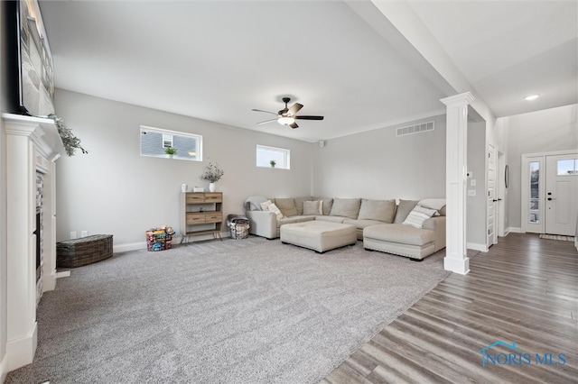 living room with hardwood / wood-style flooring, ceiling fan, and ornate columns