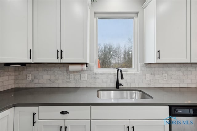 kitchen with sink, white cabinetry, stainless steel dishwasher, and tasteful backsplash