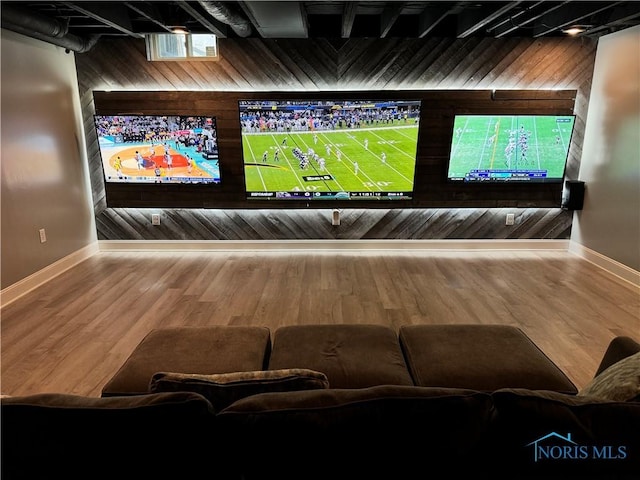 home theater room with wooden walls and hardwood / wood-style floors