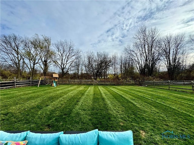 view of yard with a playground and a rural view